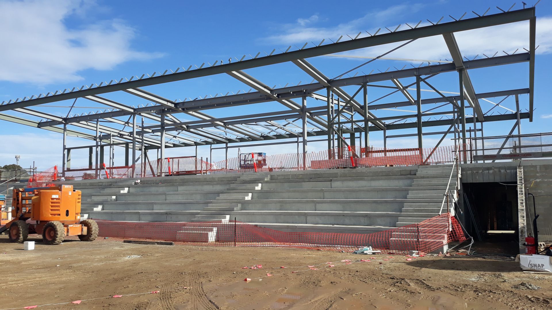 Building B (soccer) progress incl ground floor blockwork walls and teired spectator seating preparation and first floor structural steel